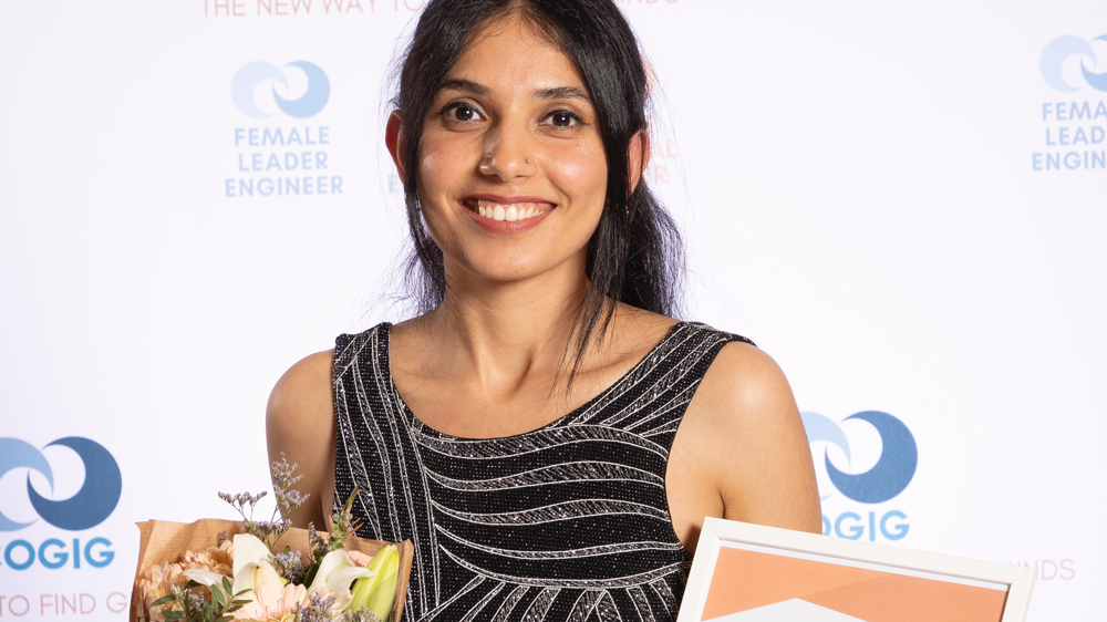 Portrait of a young woman with flowers and a diploma in her hands.