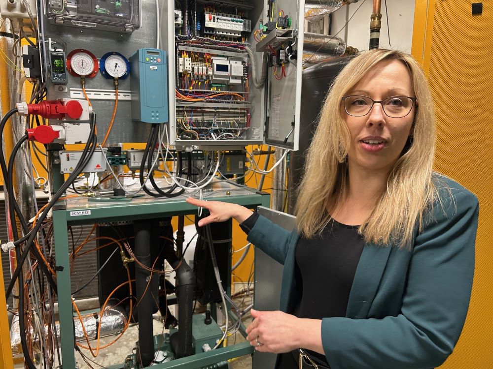 Woman in front of a heat pump.